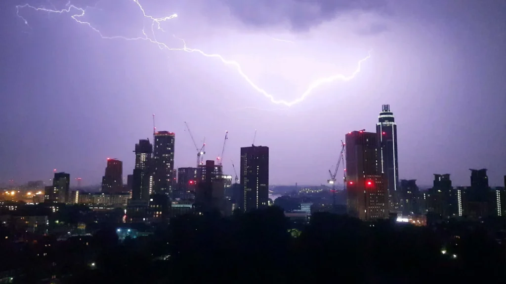 Lightning flashing over a city skyline at night.